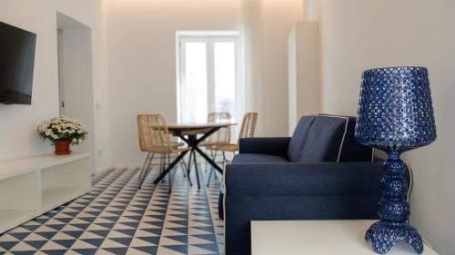 a living room with a blue couch and a table at Marina Palace Apartments & Terrace in Lipari