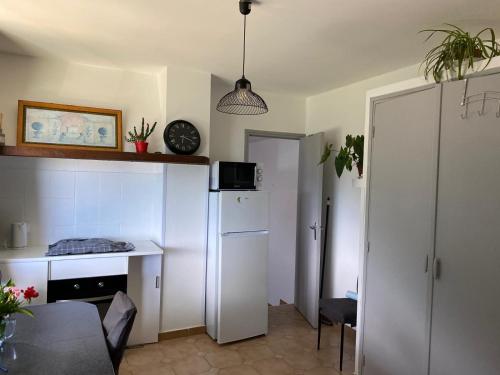 une petite cuisine avec une table et un réfrigérateur dans l'établissement Studio Cervione, à Cervione