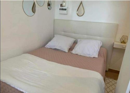 un lit avec deux oreillers dessus dans une chambre dans l'établissement Studio Cervione, à Cervione