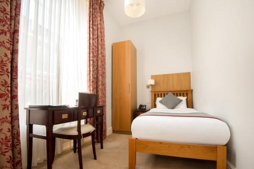 a bedroom with a bed and a desk and a chair at Dancenter Bristol near Clifton Down Station in Bristol