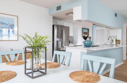a kitchen with a table with chairs and a refrigerator at Summer Winds 231-B condo in Salter Path