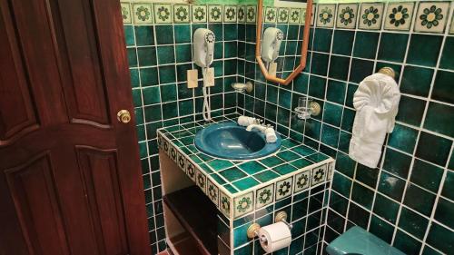 a green tiled bathroom with a blue sink at Casa Colonial Cozumel, Villa Mango in Cozumel