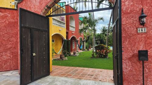 an open door of a house with a yard at Casa Colonial Cozumel, Villa Mango in Cozumel