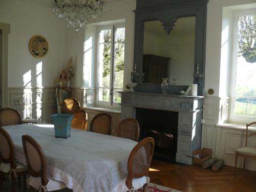 une salle à manger avec une table et une cheminée dans l'établissement Villa Boulmia, à Burlats