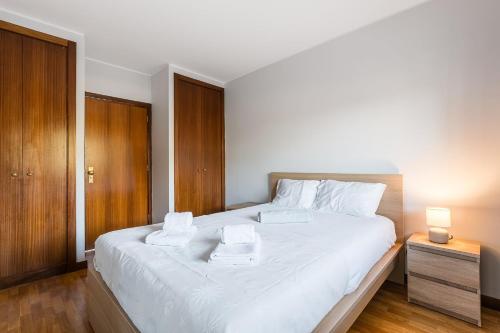 a bedroom with a white bed with two towels on it at GuestReady - Chilled getaway near Porto in Vila Nova de Gaia