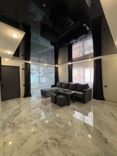 a large living room with a couch and a tv at Nirvana Lake View in Sevan