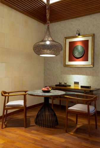 a dining room with a table and two chairs at Garrya Bianti Yogyakarta in Yogyakarta