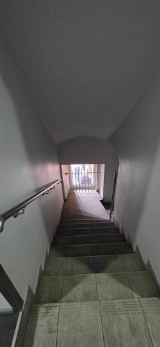 a long hallway with stairs in a building at Apartament Starówka in Nowy Sącz