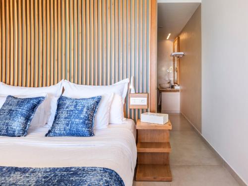 a bedroom with a bed with blue and white pillows at Anax Resort and Spa in Agios Ioannis Mykonos
