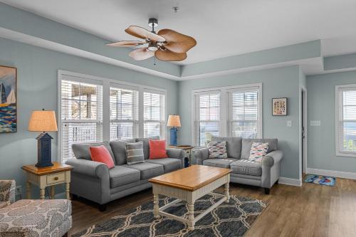 a living room with two couches and a ceiling fan at Slack Tide condo in Atlantic Beach