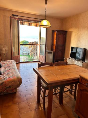 un salon avec une table et un canapé dans l'établissement Studio PORTICCIO, à Porticcio