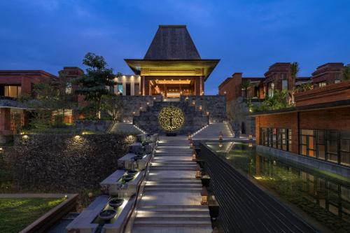 a view of a building with benches in front of it at Garrya Bianti Yogyakarta in Yogyakarta