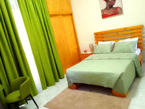 a bedroom with a bed and a green curtain at La Rouah Mishkan in Dakar