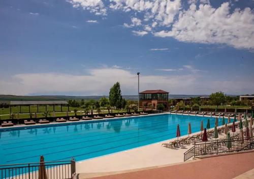 a large swimming pool with chairs and a gazebo at VILLA Kachreti Ambassadori Golf Resort in Kachretʼi