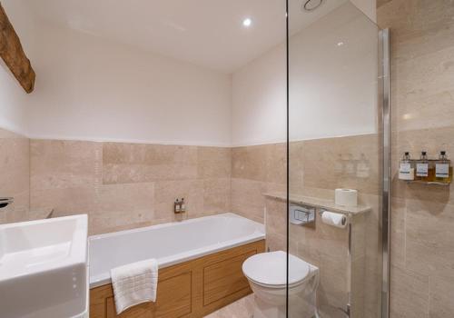 a bathroom with a tub and a toilet and a sink at The Fleece Inn in Shireshead