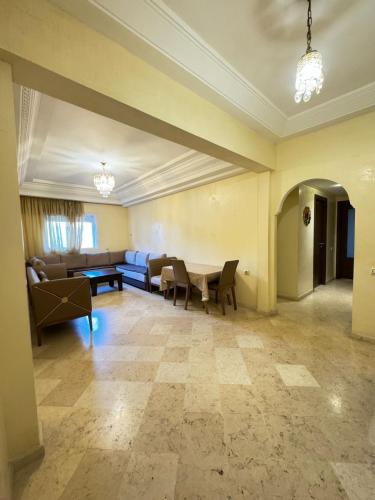 a living room with a couch and a table at Jardin mohammedia in Mohammedia