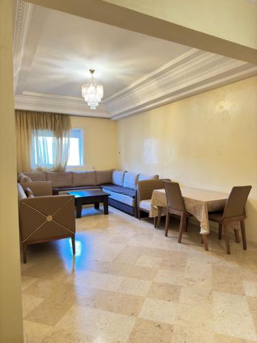 a living room with a couch and a table at Jardin mohammedia in Mohammedia