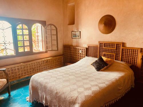 a bedroom with a bed and two windows at Villa Oceane in Taghazout