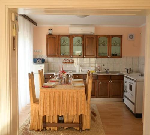 a kitchen with a table with chairs and a kitchen with at Apartmani SIMIĆ in Doboj