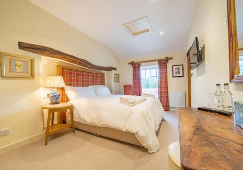 a bedroom with a large bed and a table at The Fleece Inn in Shireshead