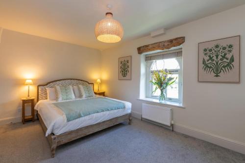 a bedroom with a bed and a window and a lamp at Ribblesdale Park in Gisburn