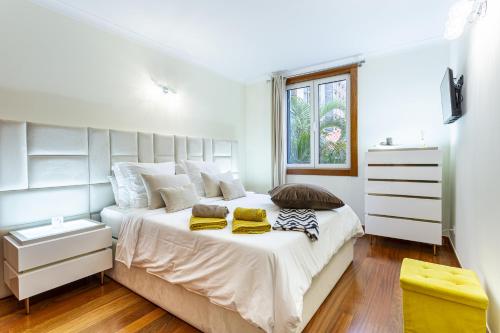 a white bedroom with a large bed and a window at Imperatriz Madeira Apartment in Funchal