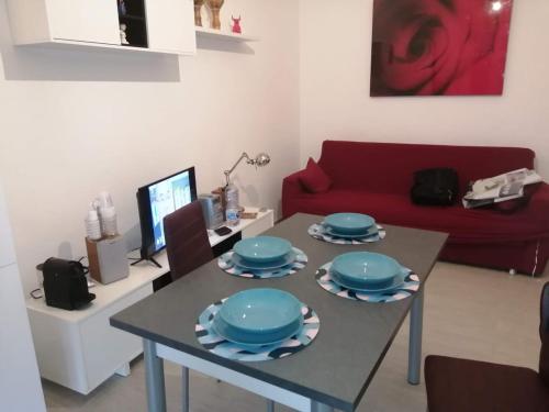 a living room with a table and a red couch at appartamento sapore di mare in Pozzallo