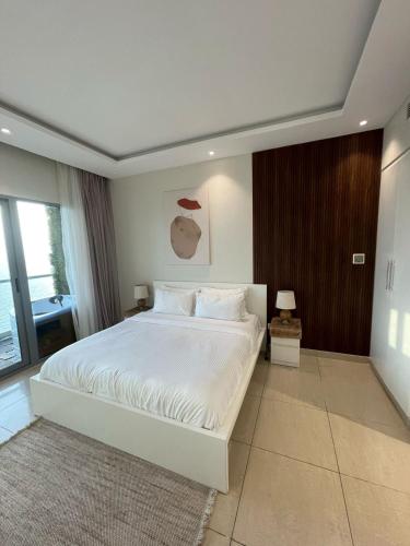 a bedroom with a large white bed in a room at شقة فاخرة بإطلالة بحرية في داماك in Jeddah
