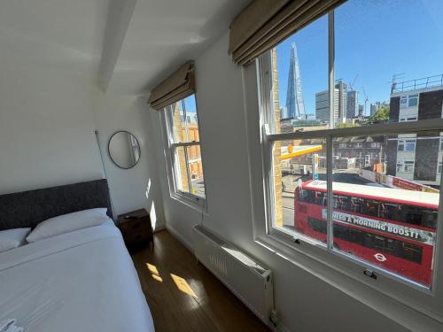 a bedroom with a bed and a window with a bus at Cosy Townhouse In Central London in London