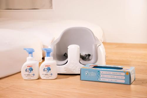 a table with three bottles of soap and a blow dryer at Of Hotel in Sendai