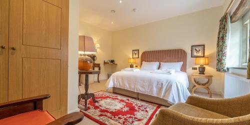 a bedroom with a bed and a couch and a chair at The Fleece Inn in Shireshead