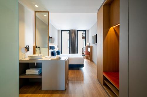 a hotel room with a bed and a mirror at Ocean Drive Madrid in Madrid