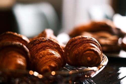 a pile of croissants on a plate on a table at ゲストハウス桜月荘 in Kagoshima