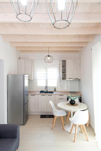 a kitchen with a refrigerator and a table and chairs at Nina's Apartments in Kómi