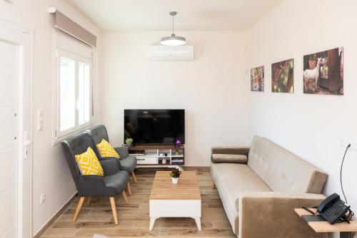 a living room with a couch and two chairs at Nina's Apartments in Kómi