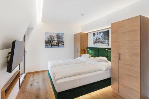 a bedroom with a large white bed and a tv at Gasthof zum Goldenen Hirschen in Ybbsitz
