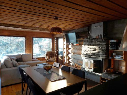 a living room with a table and a fireplace at Kotkas in Syöte