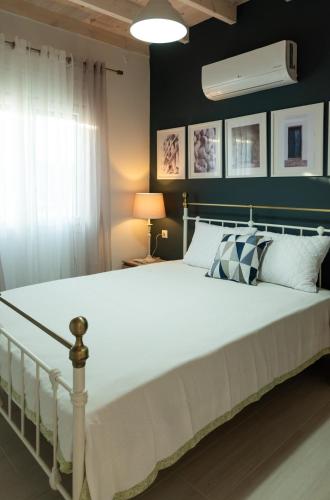 a bedroom with a large white bed and a green wall at Nina's Apartments in Kómi