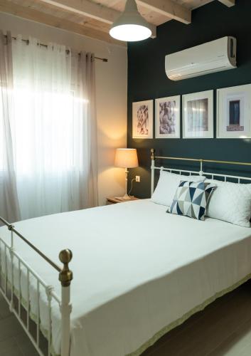 a bedroom with a large white bed and a window at Nina's Apartments in Kómi