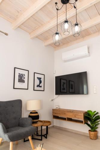 a living room with a tv and a chair at Nina's Apartments in Kómi