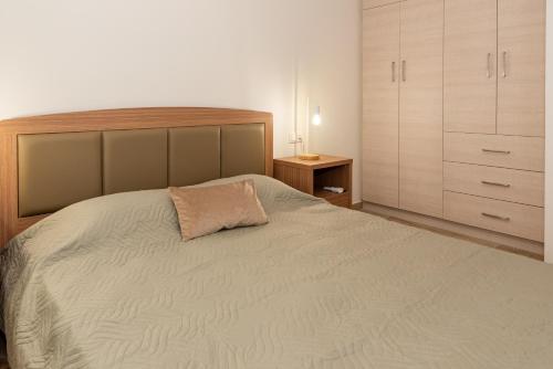 a bedroom with a large bed with a pillow on it at Nina's Apartments in Kómi