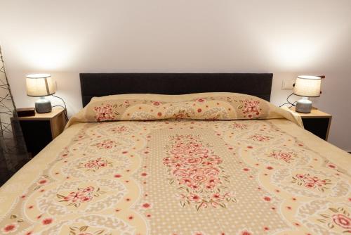 a bedroom with a bed with two lamps on both sides at Nina's Apartments in Kómi