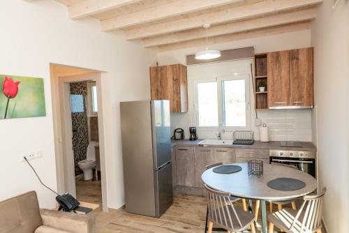 a kitchen with a table and a stainless steel refrigerator at Nina's Apartments in Kómi