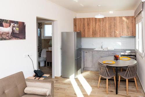 a kitchen with a table with chairs and a refrigerator at Nina's Apartments in Kómi