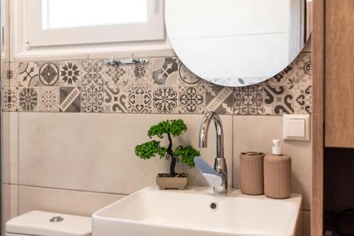 a bathroom with a sink and a mirror at Nina's Apartments in Kómi