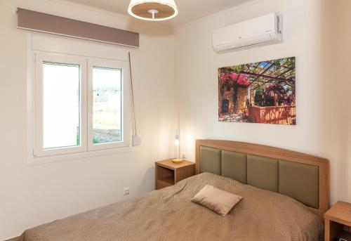 a bedroom with a bed and a picture on the wall at Nina's Apartments in Kómi