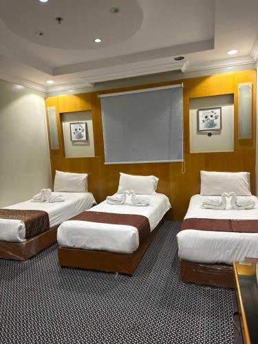 a room with three beds and a projection screen at فندق المغاربي للشقق الفندقية in Al Madinah