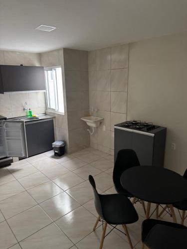 a kitchen with a table and chairs and a sink at Edifício Ribeiro in Patos
