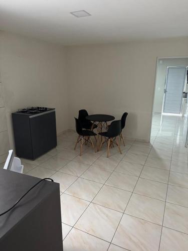 a kitchen with a table and chairs in a room at Edifício Ribeiro in Patos