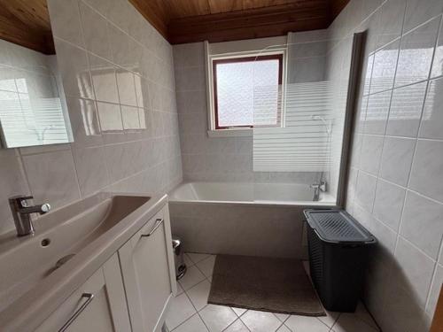 a white bathroom with a tub and a sink at LES REFUGES DU LOT Kouki's Lodge in Mauroux
